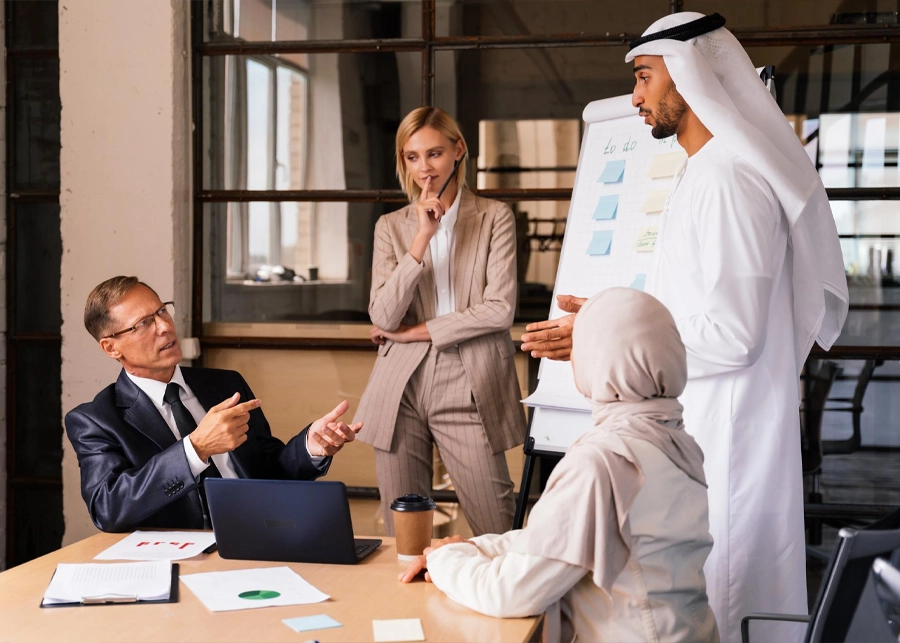 فريق عمل من المستثمرين الأجانب يخططون لخطوات تأسيس شركة في دبي مع ملكية 100%.